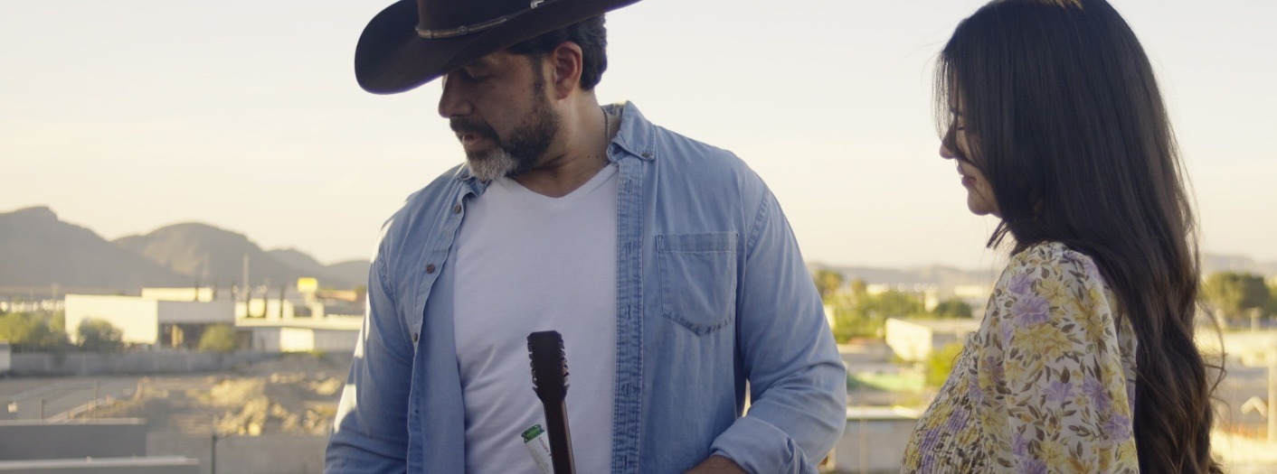 Pareja preparando carne asada en la terraza al atardecer