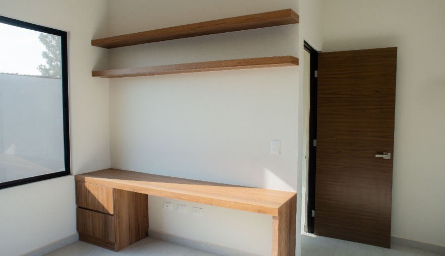Cuarto flex de la Casa Encino durante la obra, con escritorio y repisas de madera
