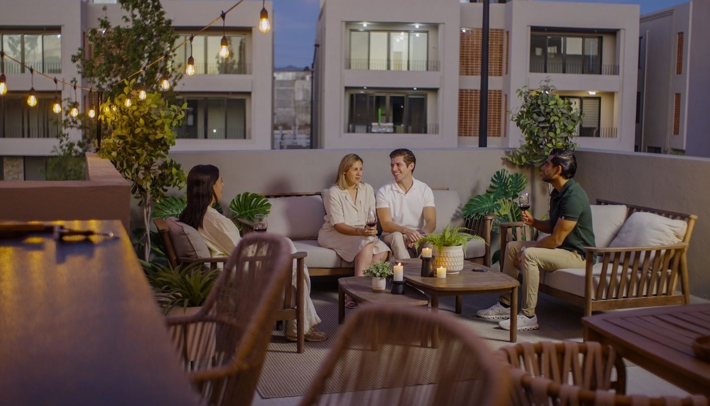 Amigos conversando en la terraza de la Casa Encino al anochecer